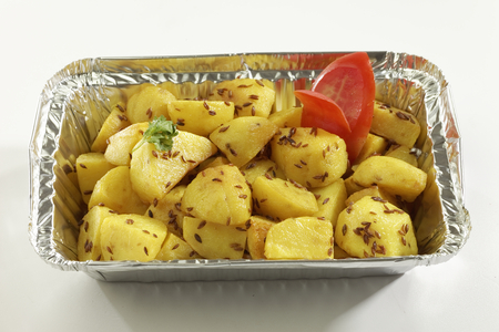 Indian dish fried potato with cumin in metal foil tray.の写真素材