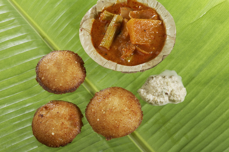 South Indian fast food fried idly with coconut chutney and sambar on green banana leaf.の写真素材