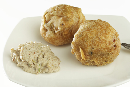 Fast food deep fried batata potato vada with chutney on white background.の写真素材