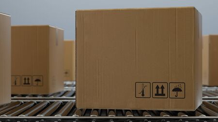 Cardboard boxes on conveyor belt line isolated on white gray background. Distribution warehouse. E-commerce, production, storage, delivery and packaging service concept. 3d renderingの写真素材