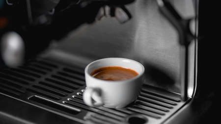 Morning coffee preparation. Coffeemaker. Close-up view of bartender preparing coffee on modern...