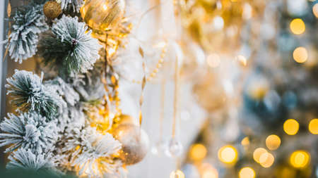 Bright New Year celebration dÃ©cor. Christmas and New Year interior in light classic style. White room with Xmas Tree decorated, flashing garland and gold balls. Winter Holiday Backgroundの写真素材