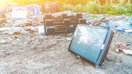 Crashed TV set with blank screen at dumping area. Vintage cathode ray tube at waste land. Abandoned electrical equipment. Electrical waste recycling and ecologyの写真素材