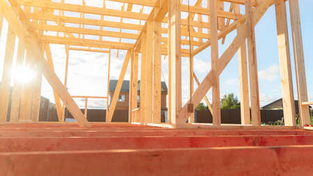 Carcass of wooden beams at cottage construction site on sunny day closeup. Old tradition of building at rural site. organic materials. industrial processの写真素材