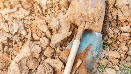 Dirty shovels and dug clay soil view from above. Gardening tools and ground processing. Preparing dirt for planting. Agricultural works and farmingの写真素材