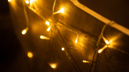 Fairy lights mesh on decorative deer in Christmas interior design closeup. Garland of glowing lamps...