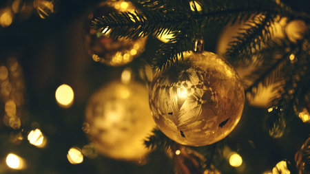 Christmas tree branches with flowing fairy lights indoors closeup. Brilliant festive ornament with lamp garland on fir tree at home. Holiday decor with warm lights at domestic Xmas partyの写真素材