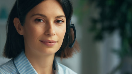 Young woman working in a call center. Happy smiling call center operator answering phone calls...