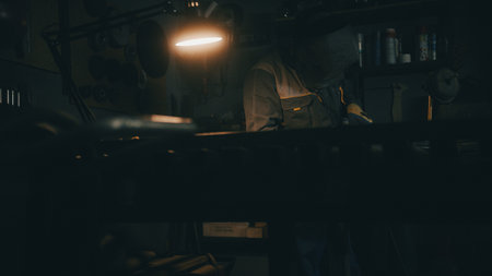 A man works with a welding machine at a factory. A welder welds metal in a workshop. Sparks fly from hot metal. The man worked hard on the steelの写真素材