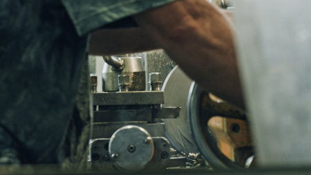 Close up of a metalworker operating a lathe machine, shaping a metal part in a workshop, showcasing...