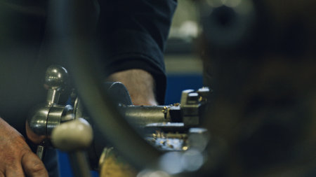 Close up of skilled metalworker operating a lathe machine, shaping metal in a factory workshop, demonstrating industrial manufacturing processes and precision engineeringの写真素材