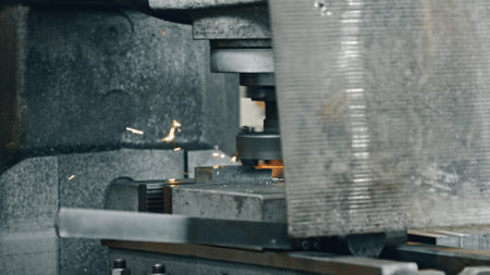 Heavy machinery processing metal components generates sparks in a bustling factory setting,...