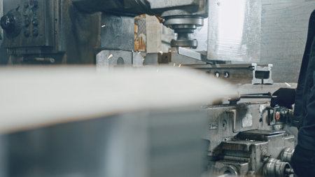 Milling machine cutting through metal in a factory workshop, generating bright sparks and illustrating the intricate process of industrial manufacturing and metalworkingの写真素材