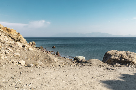 Landscape view of a rocky island and a tursquoise sea horizon line.の写真素材
