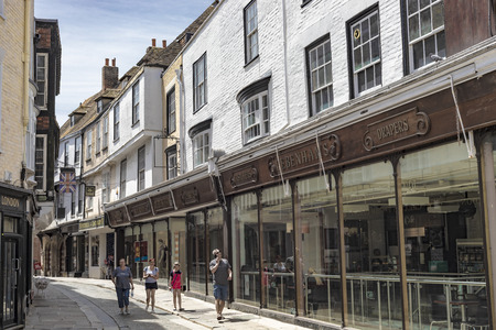 Canterbury, England - June 24, 2018: Street view with ancient buildings turned into shops and people...