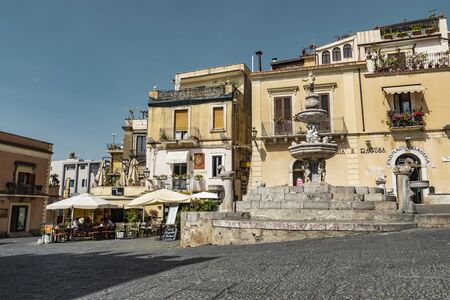 Taormina Sicily, Italy - July 9 2019: Architectural view of the fountain, houses and restaurant in Piazza Duomoのeditorial素材