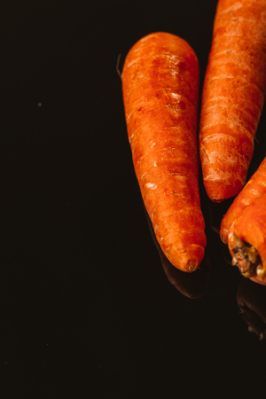 Fresh raw carrots on a black background.の写真素材