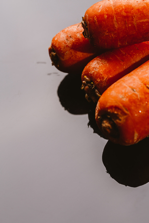Fresh raw carrots on a black background.の写真素材