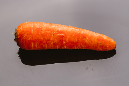 Fresh raw carrots on a black background.の写真素材