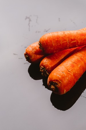 Fresh raw carrots on a black background.の写真素材