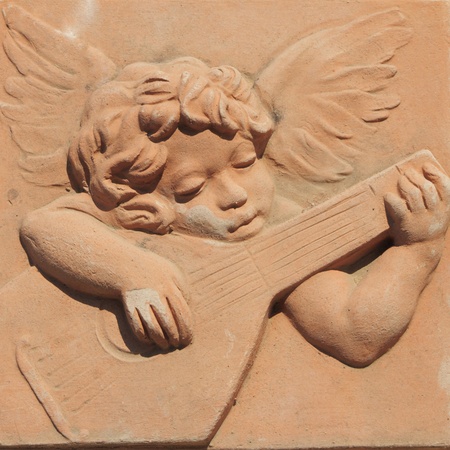 angel playing guitar in terracotta from famous tuscan Impruneta, Italyの写真素材