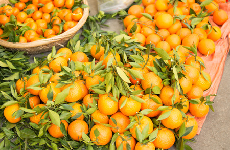 Bunch of fresh tangerines oranges on roadside marketの写真素材