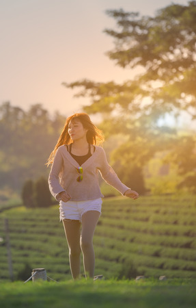 Happy asian lady walk on grass in garden in sunny day.の写真素材