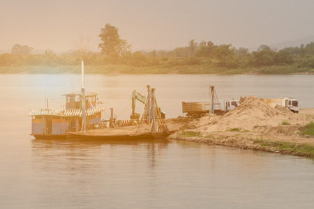 Dump truck ,shovel buckets,sand boat on river bank in construction site.の写真素材