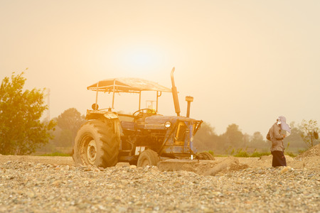 Tractor with worker on duty,constructor site.の写真素材
