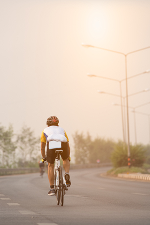 Asian young man ride a bike on road in morning.の写真素材