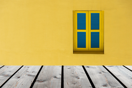 Wood floor with closed yellow and blue window on yellow wall background . can be used for display or montage your productsの写真素材
