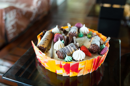 Colourful soft cake with chocolate roll and white cream on top,ready for serve in hotel bar.の写真素材