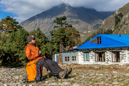 Side view portrait of young trekker man sit on the chair looking to everest base camp trek routeのeditorial素材