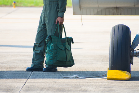 pilot leg standing beside airplane with bag in hand.
