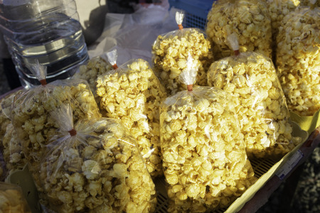 Buttered sweet popcorn in bags at street food stall in local market in Thailand.の写真素材