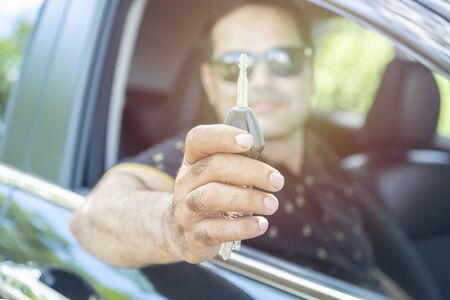 pakistani muslim Man sit in car and showing car keyの写真素材