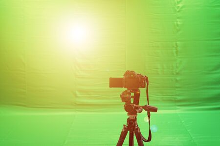 Videographer taking video camera, camera equipment film stand by on green screen.の写真素材