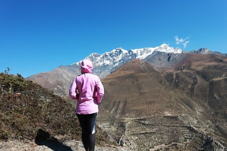 Asian woman trekker in valley of Everest base camp trekking route in Khumbu ,Nepal with snow...