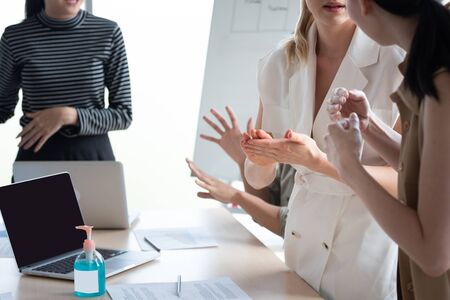 Hand of conference business coworker in workplace rub hand after get sanitizer alcohol gel spray protect from coronavirus or covid-19 virus world pandemic,health care and medicine concept.Gel on tableの写真素材