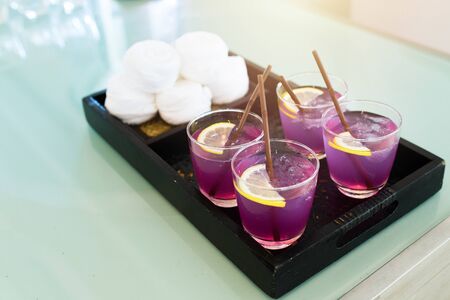 Tray of softdrink welcome drink glasses for welcome new customer to hotel of party nightclub and restaurant,sparkling nightlife in background.の写真素材