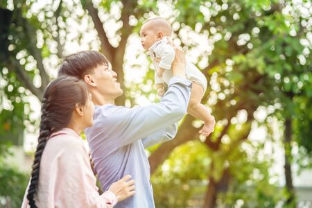 Happy family concept.Happy young asian couple parent having fun with little son,Dad holding up male...