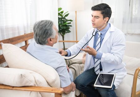 Caucasian doctor use laptop and talk with old asian male patient about disease symptom, elderly...