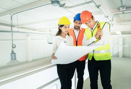Businessman or engineer architect mixed race young caucasian man and asian woman wear hard hat...