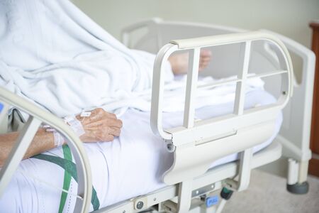 Hand of elder Asian woman patient on bed in hospital