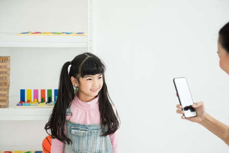 adorbale daugther smile look at mother phone at home.