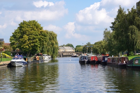ELY, UK - SEPTEMBER 15 2015: Colourful river boats and canal boats line the banks of the River Great Ouse in Ely, Cambridgeshire.のeditorial素材