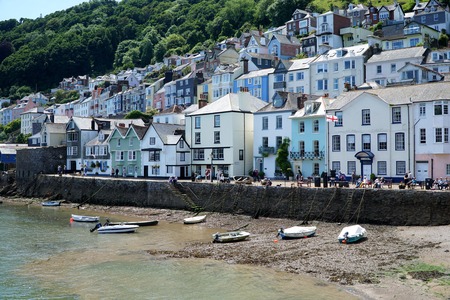 DARTMOUTH, UK - JULY 6 2016: People sit and walk on the riverside promenade in the popular tourist...