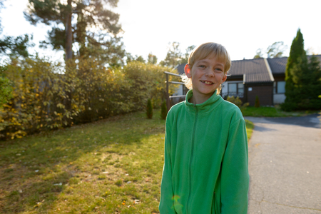 Happy boy smiling in the front yard at homeの写真素材