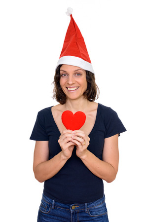 Studio shot of happy Caucasian woman ready for Christmas holding red heart isolated against white backgroundの写真素材