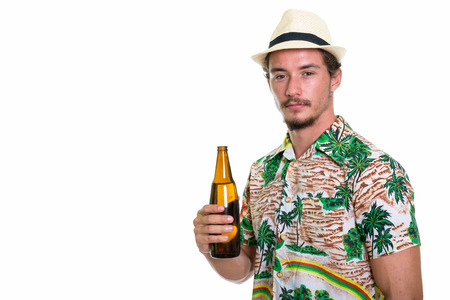 Studio shot of young handsome tourist man holding bottle of beerの写真素材